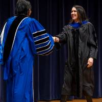 President shaking hands with faculty